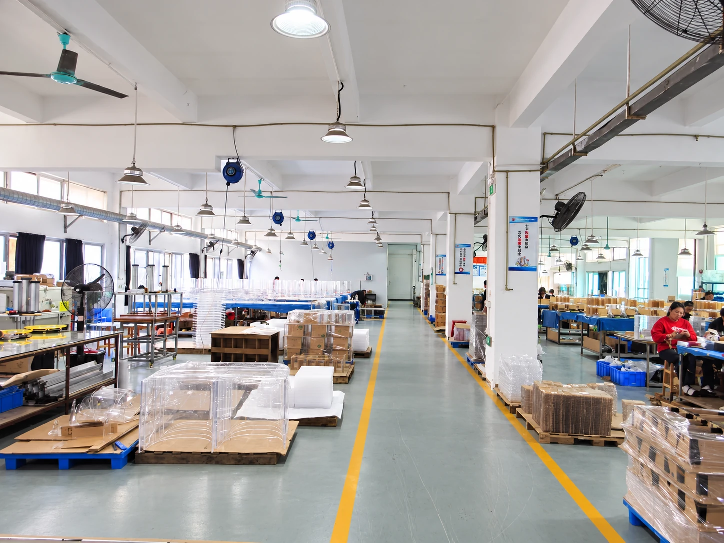 Acrylic display workshop with a central aisle, clear components, worktables and material pallets