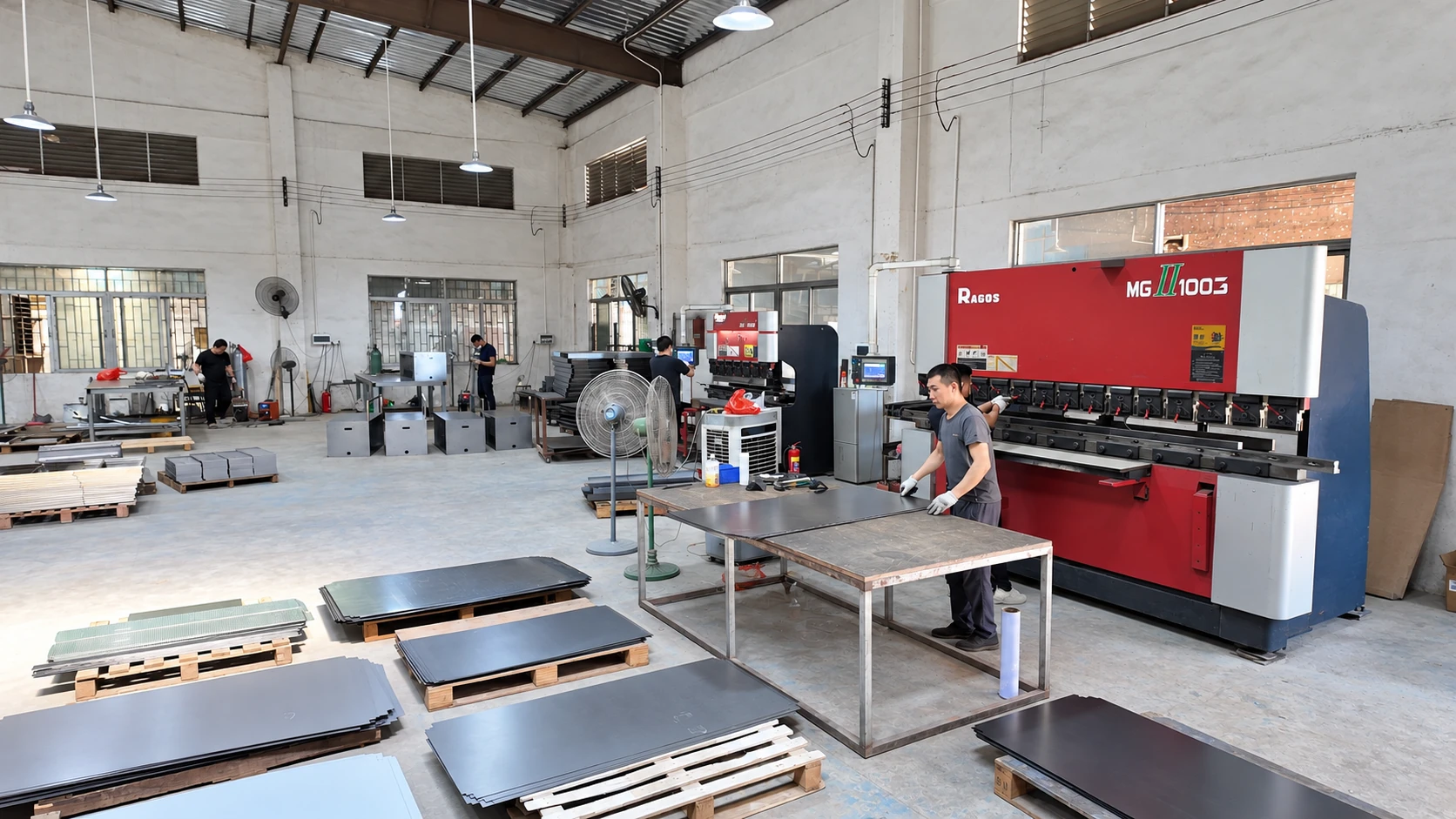 Metal fabrication workshop with a red press brake, sheet panels and workstations